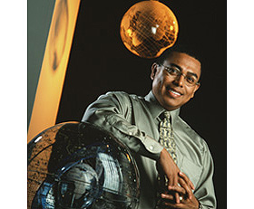 University Photography Professor Arlie Petters poses with a model of the solar system