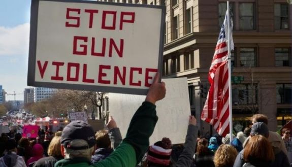 person holding up sign that says Stop Gun Violence
