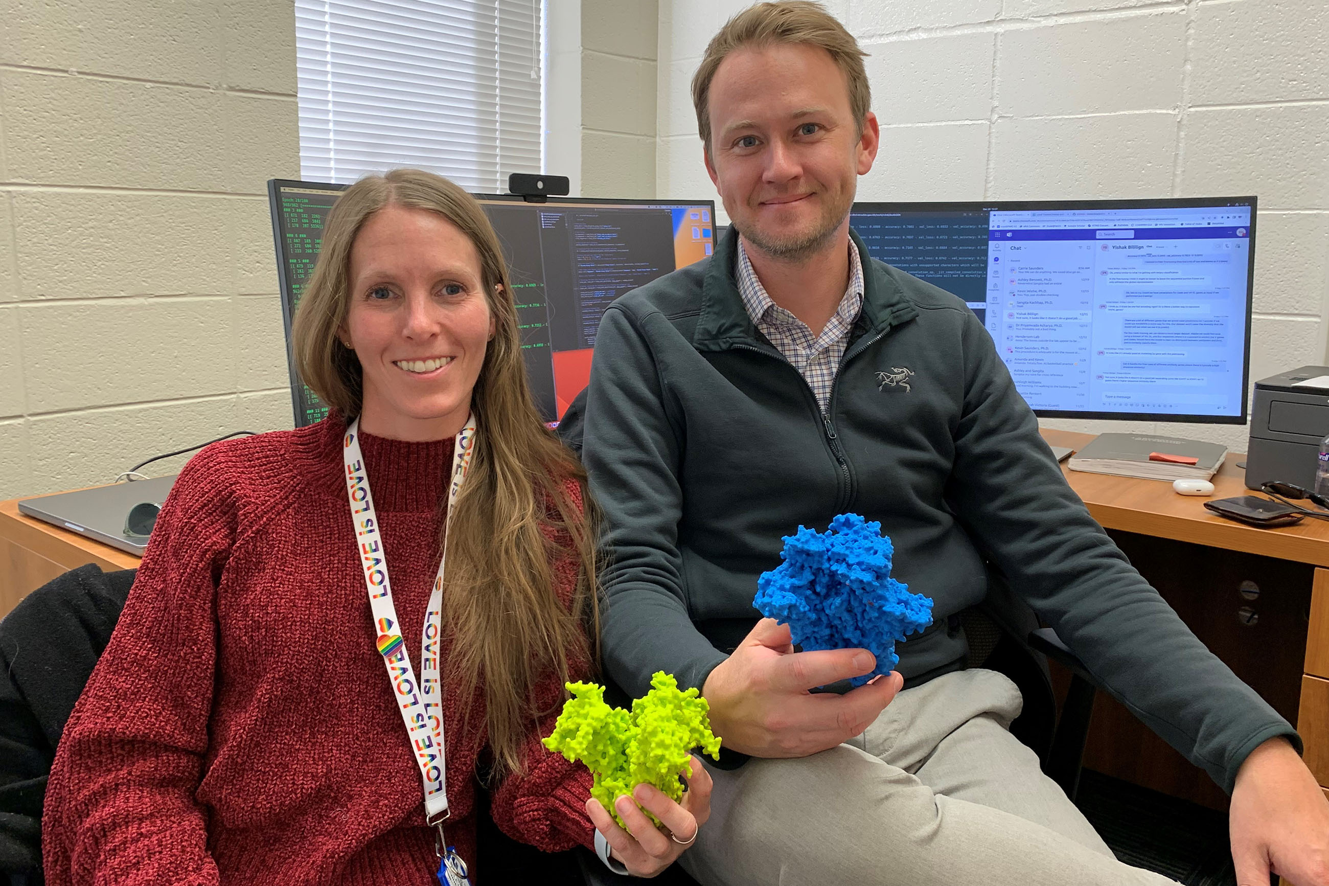 Ashley Bennett and Rory Henderson holding 3D plastic models of the molecule
