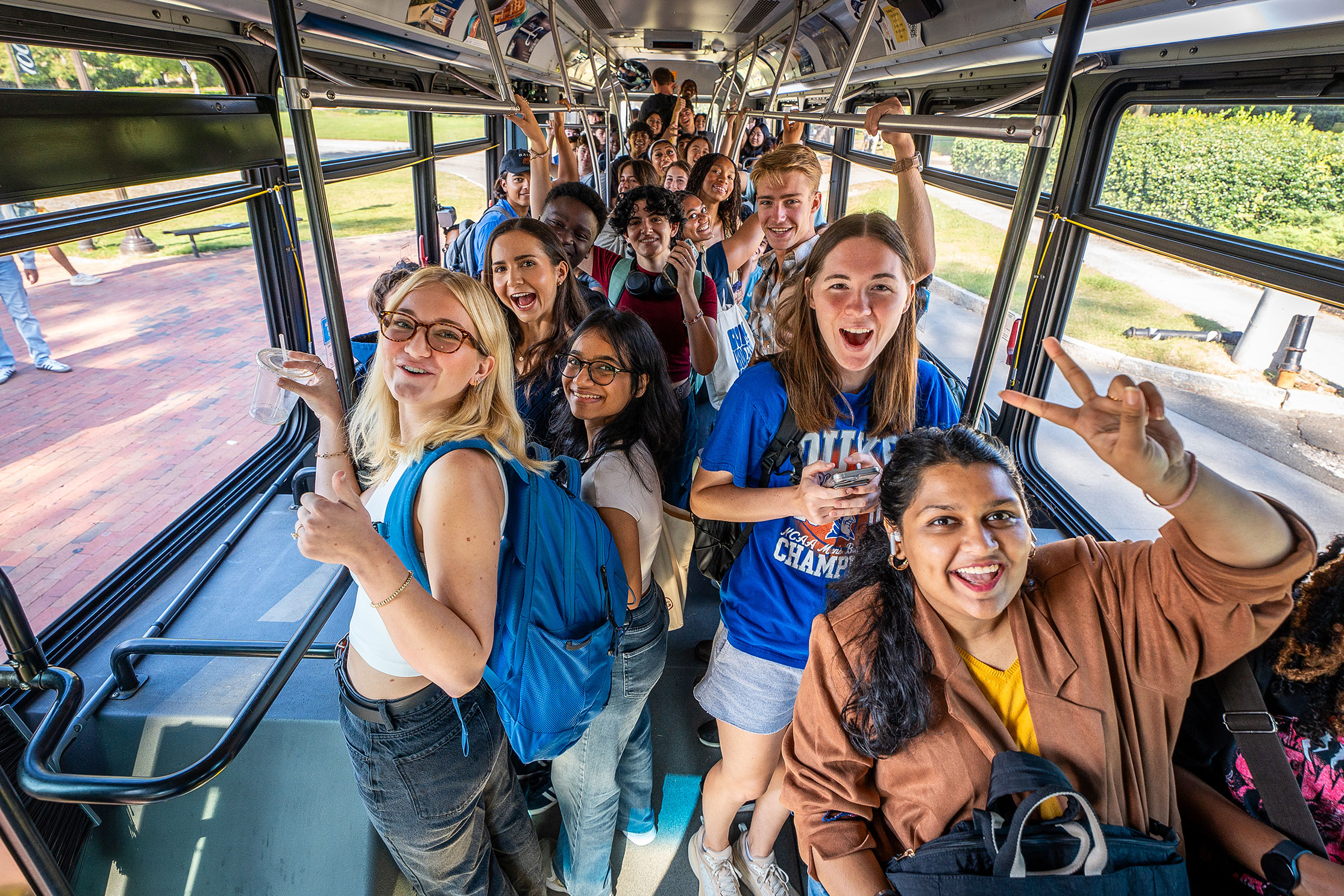 Students give a cheer for the start of the semester while on the East-West bus
