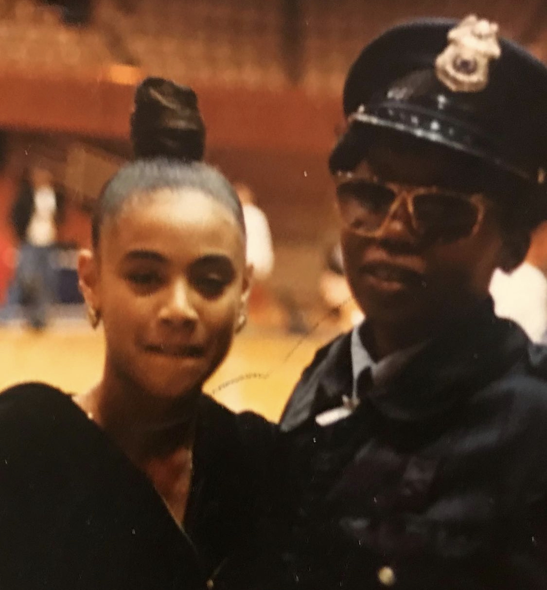 A Duke police officer stands to the right of a a very young actress Jada Pinkett Smith