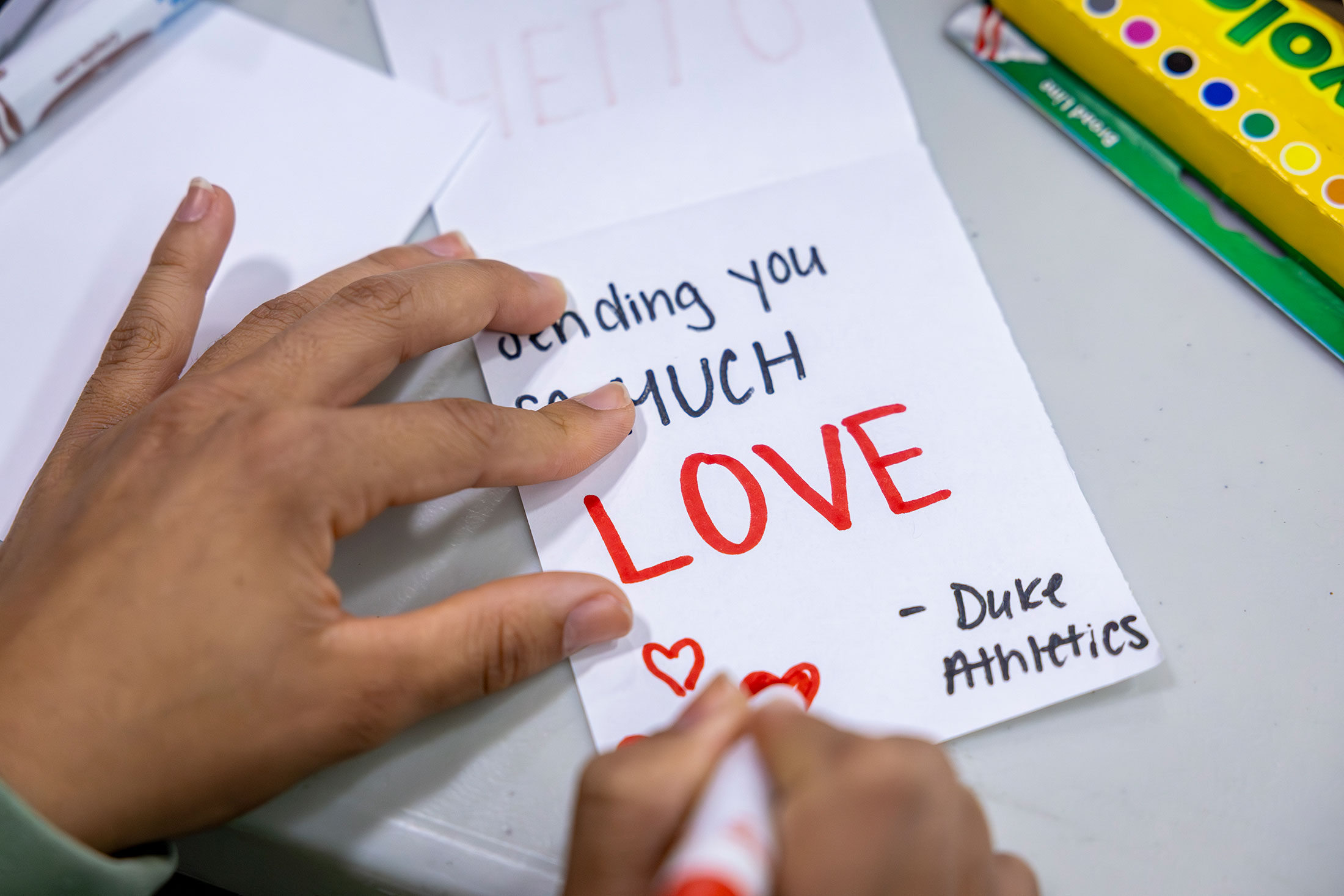Student writes a note for inclusion in the backpack. It says Sending you much LOVE
