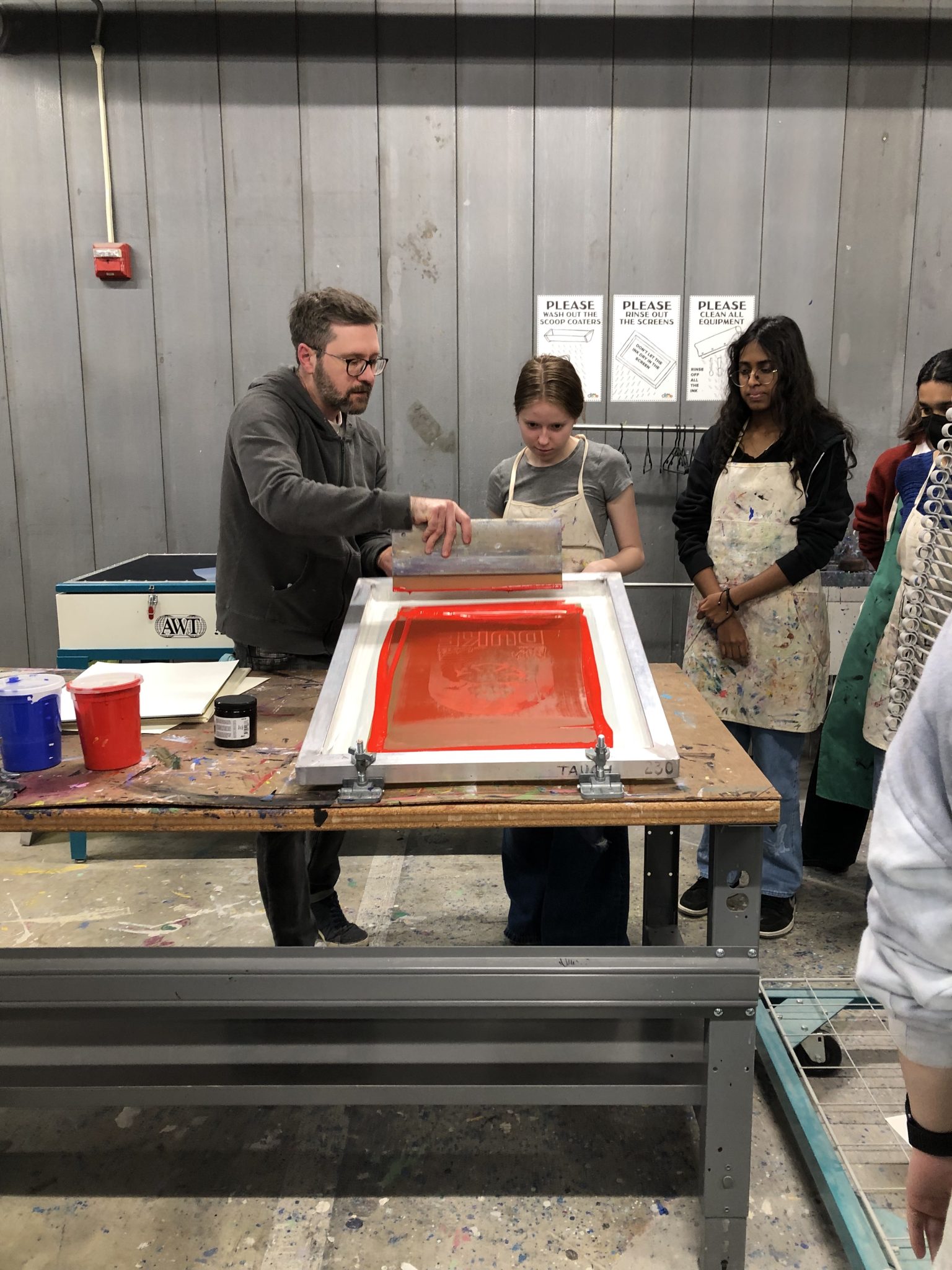 A man prepares to demonstrate screen printing for onlookers