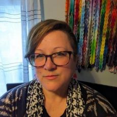 A headshot of a woman in glasses