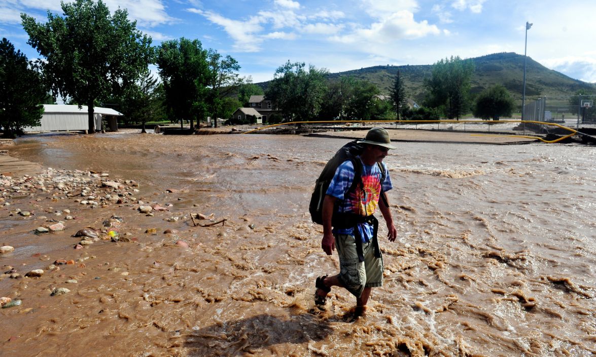 Person walking through a flooded park.