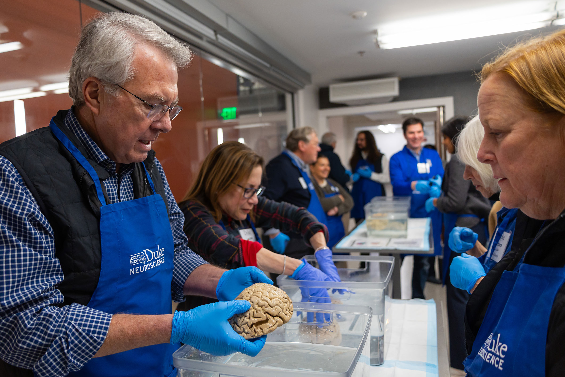 Duke instructor holds human brain in his hands at a Duke neuroscience event during the campaign launch.