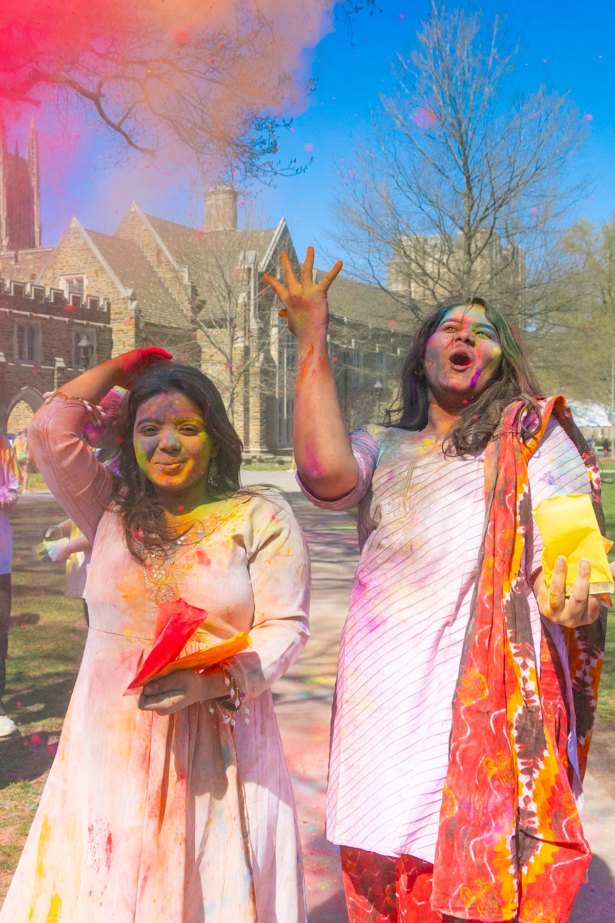 two women in south asian cheer during the tossing of the colors
