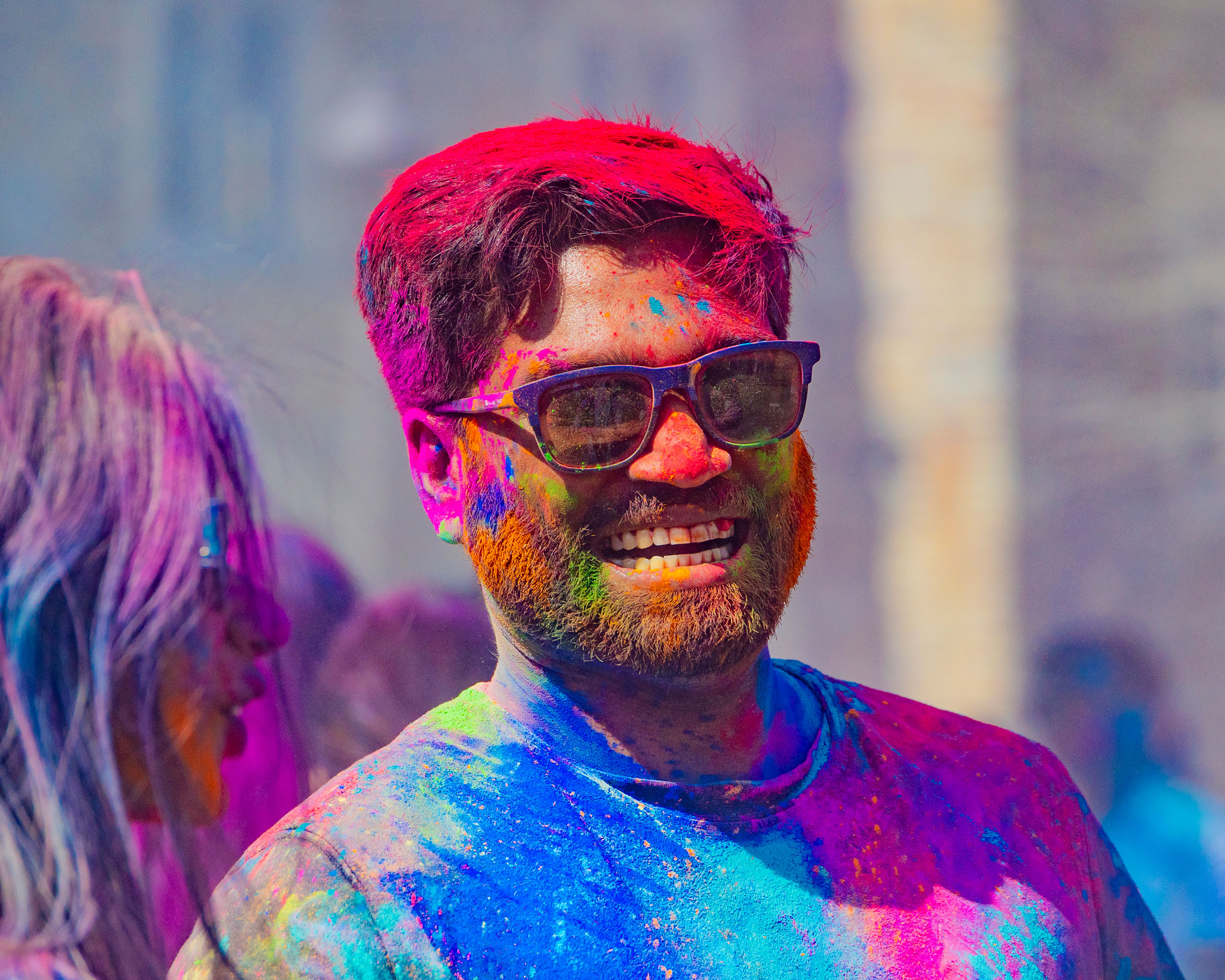 male student covered with Holi colors on his face