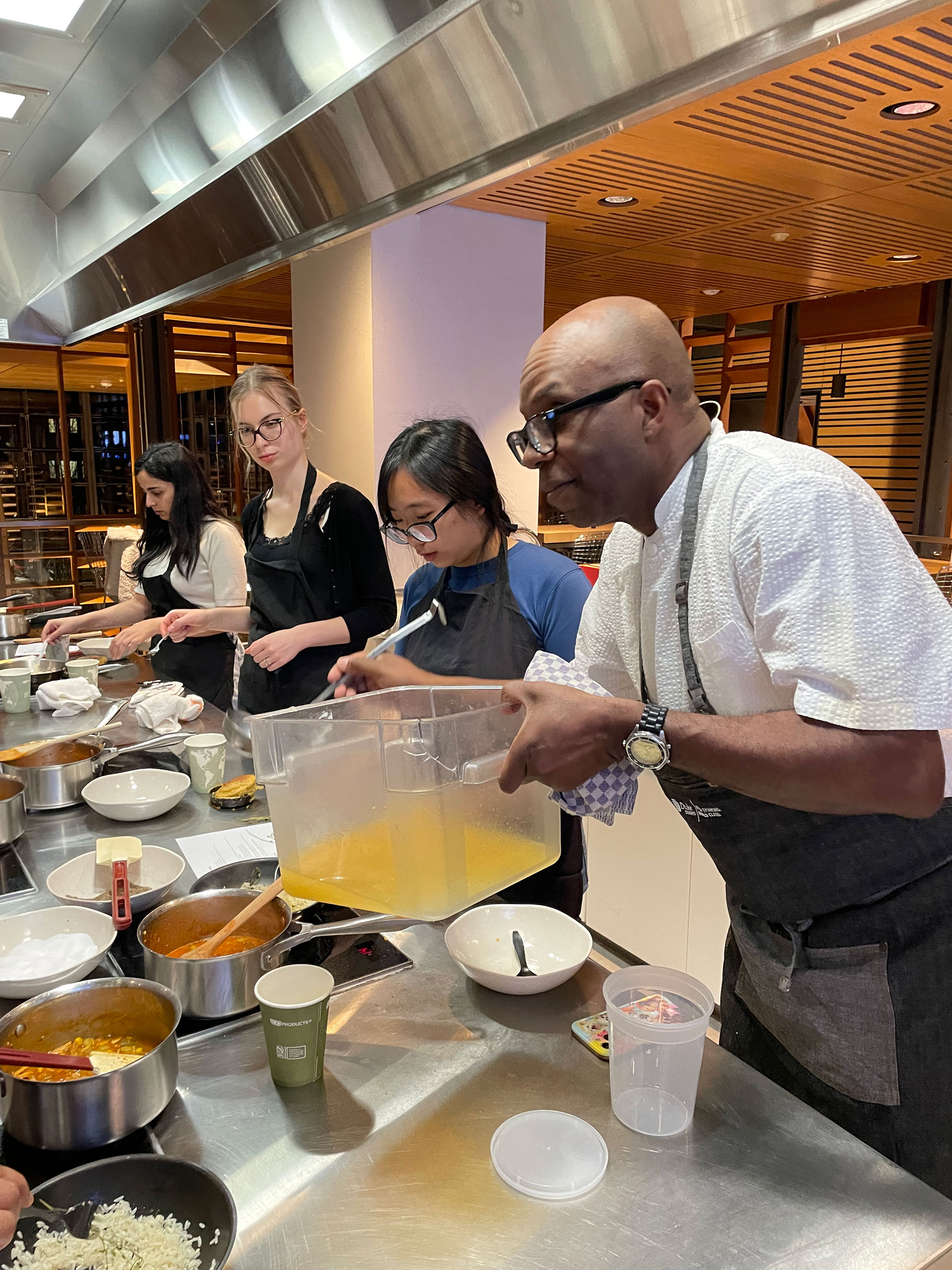 Ricky Moore pours in a sauce into a dish
