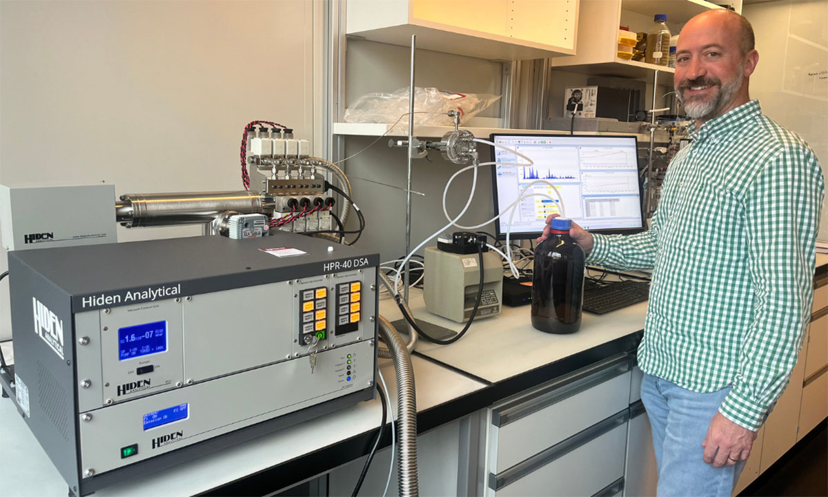 Lee Ferguson stads with lab equipment to test water