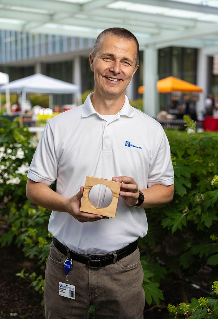 A man holds a wooden propagation station