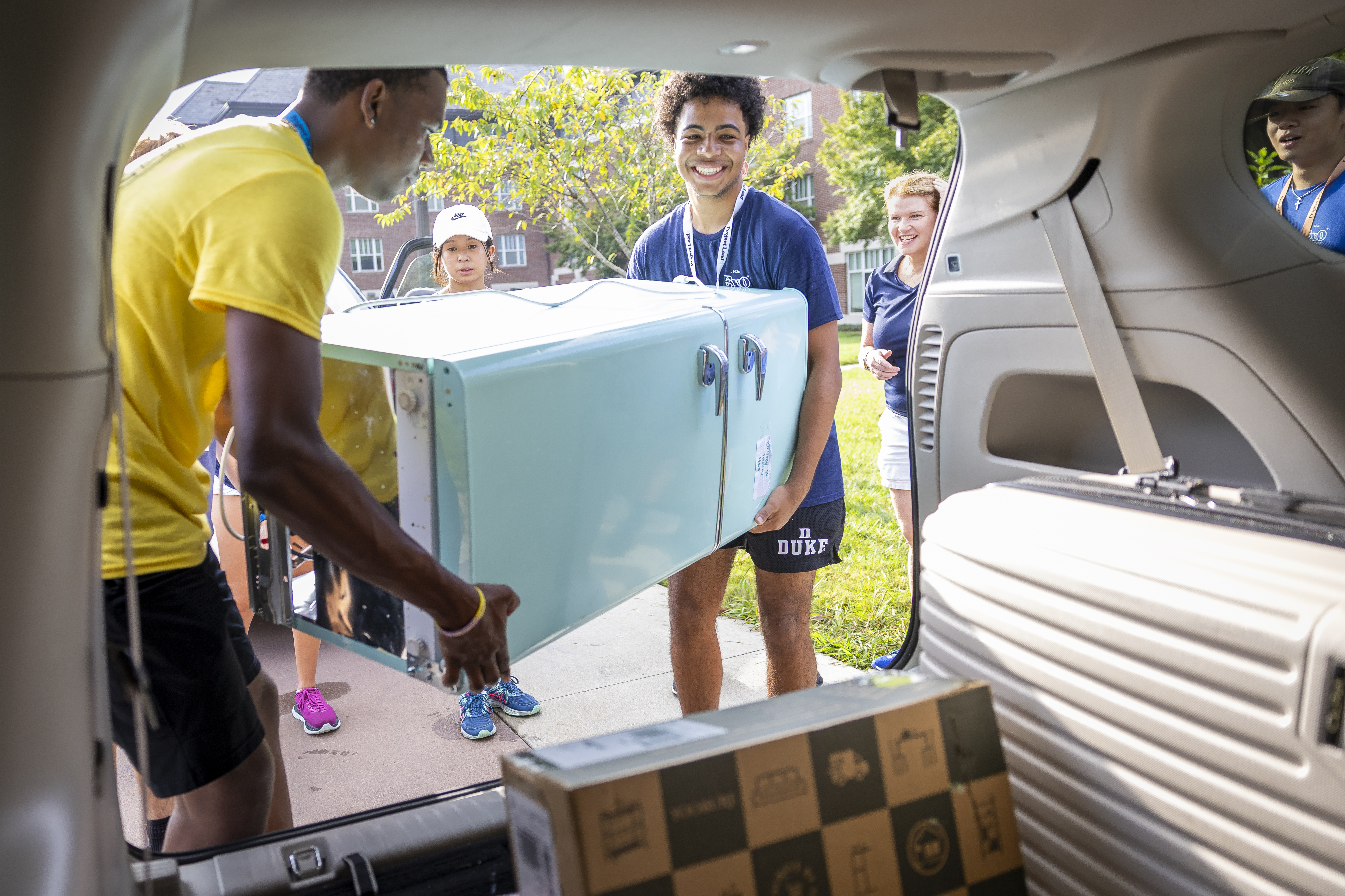 Twopeople unpacking a fridge.