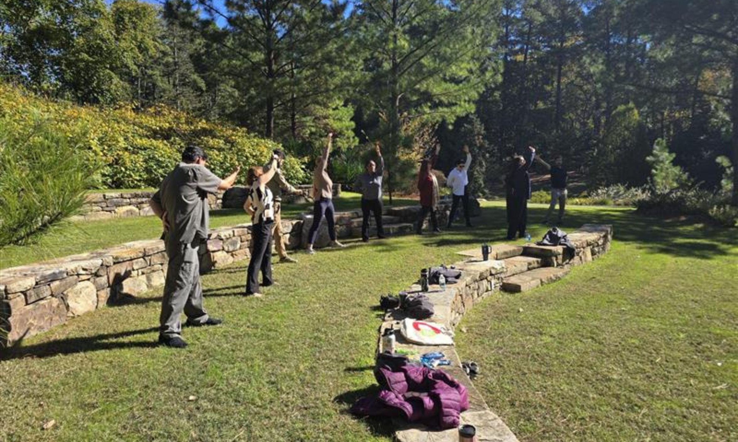 A group of people practice qigong in Duke Gardens