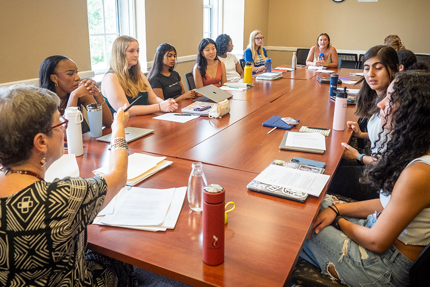 A class sitting around a table having a discussion