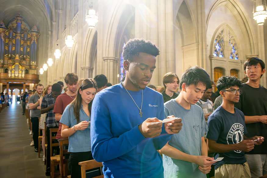 Students fill the rows in Duke Chapel singing the alma mater