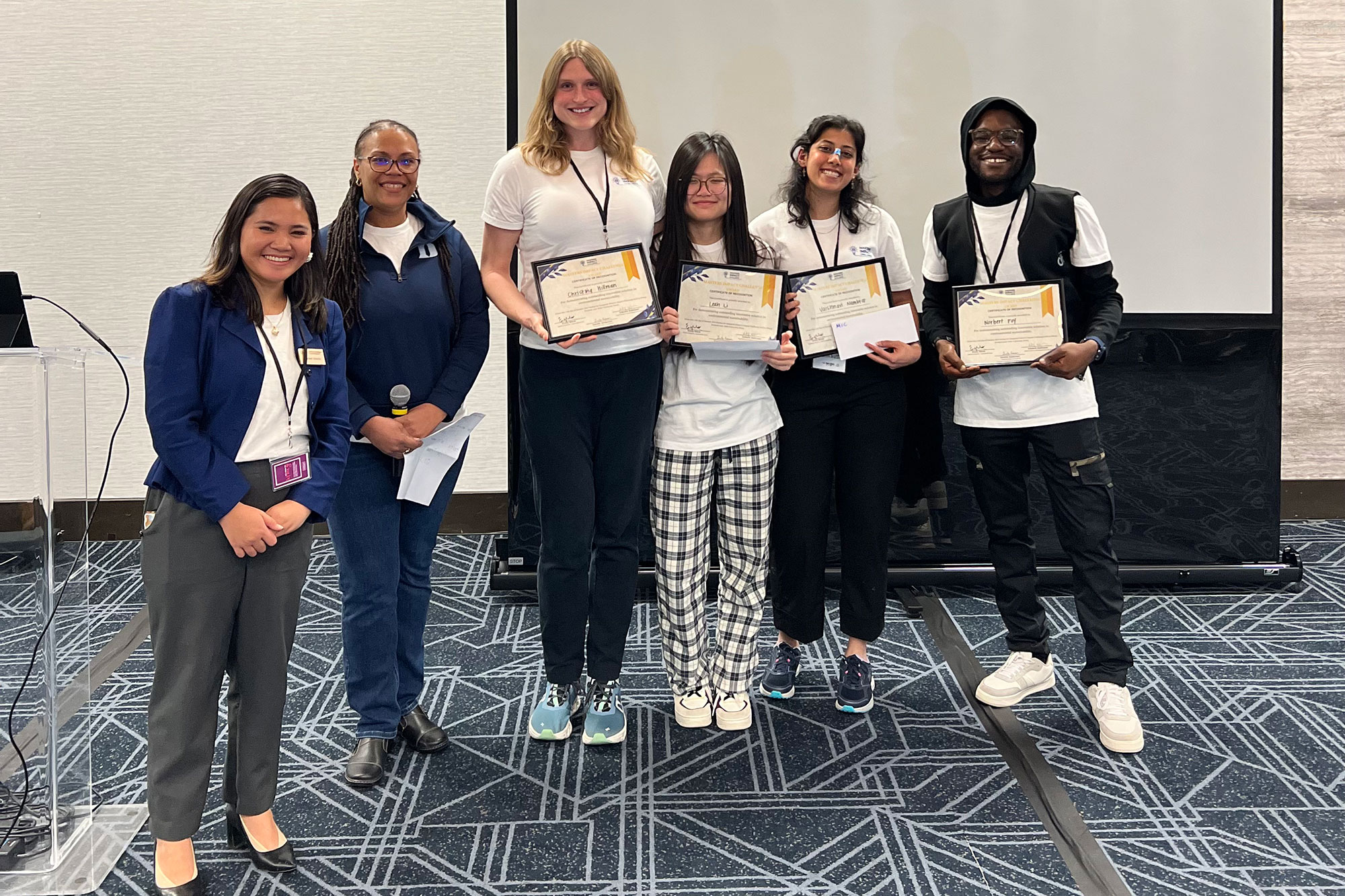 Adrienne Stiff-Roberts (second from left), with members of the Green Devils, winners of the weekend’s Masters Impact Challenge Award.