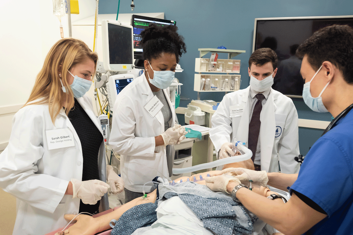 Congressional staffers Sarah Gilbert, Kichelle Webster and Sean McCabe are trained by anesthesiology resident Dr. William Fox in a simulation session. Photos by Les Todd