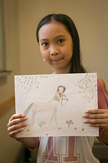 A young Vietnamese refugee proudly shows off her artwork. Photo by Jared Lazarus