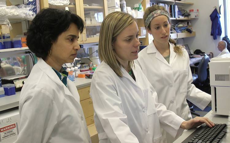 Dr. Smita Nair, left, working in the lab with colleague researchers. Photo by Shawn Rocco/Duke Health