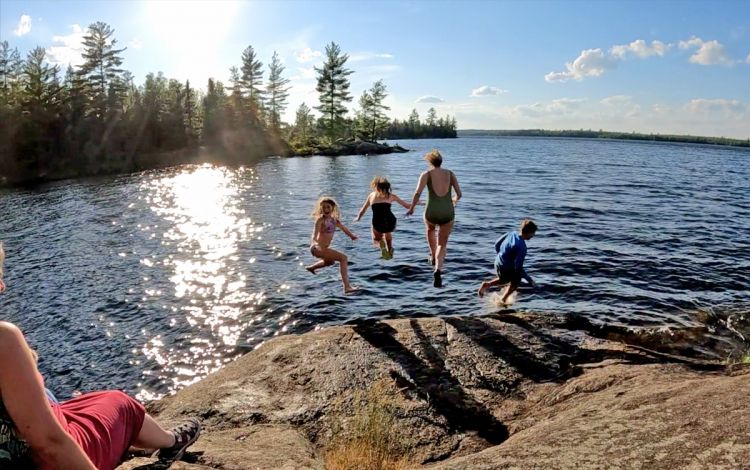 People jumping into a lake