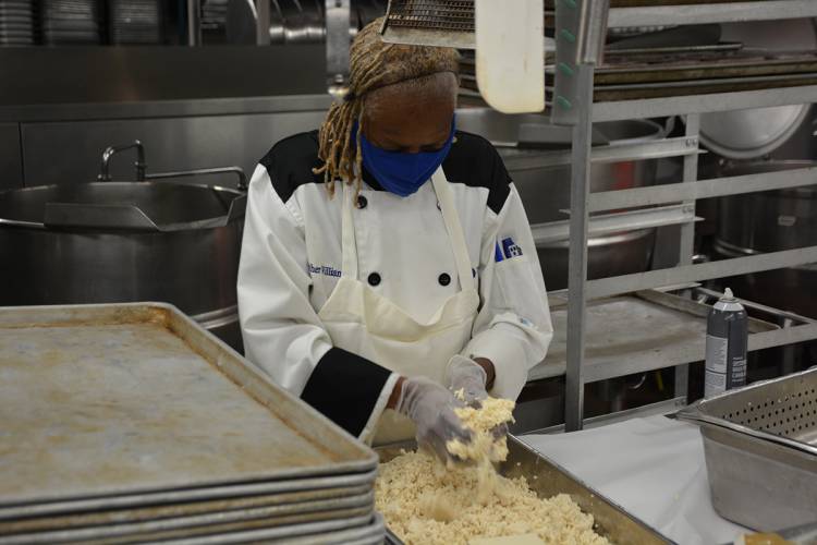 Esther Williams crumbles up tofu in the Marketplace kitchen on Aug. 7. Photo by Jonathan Black.