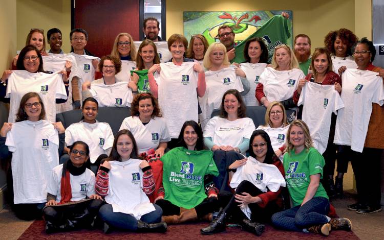 Employees showing off their T-shirts.