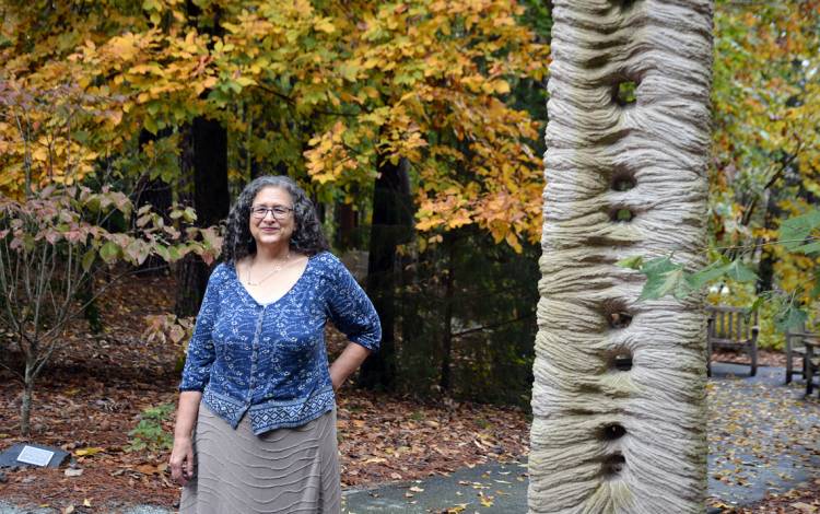 Janet Silber stands next to the sculpture, “Jacob’s Ladder,