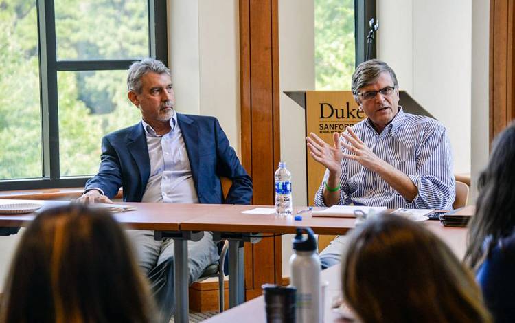 Mac McCorkle, right, covers the background to the six constitutional amendments on the state ballot this election at a Duke talk. Photo by Joel Luther.