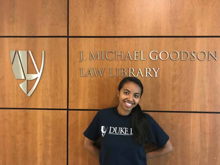 Fifaliana Ratodimahavonjy poses for a photo next to the J. Michael Goodson Law Library sign inside of Duke Law School