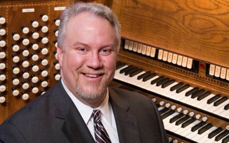 A man in front of an organ.