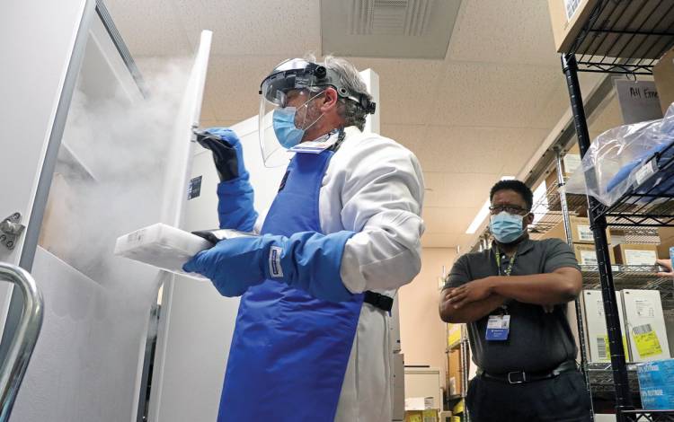 Daryl Blackburn, Duke Regional Hospital Pharmacy’s assistant director, wears protective eyewear and gloves to store the hospital’s first shipment of the Pfizer/BioNTech COVID-19 vaccine in an ultra-cold freezer. Photo by April Dudash.