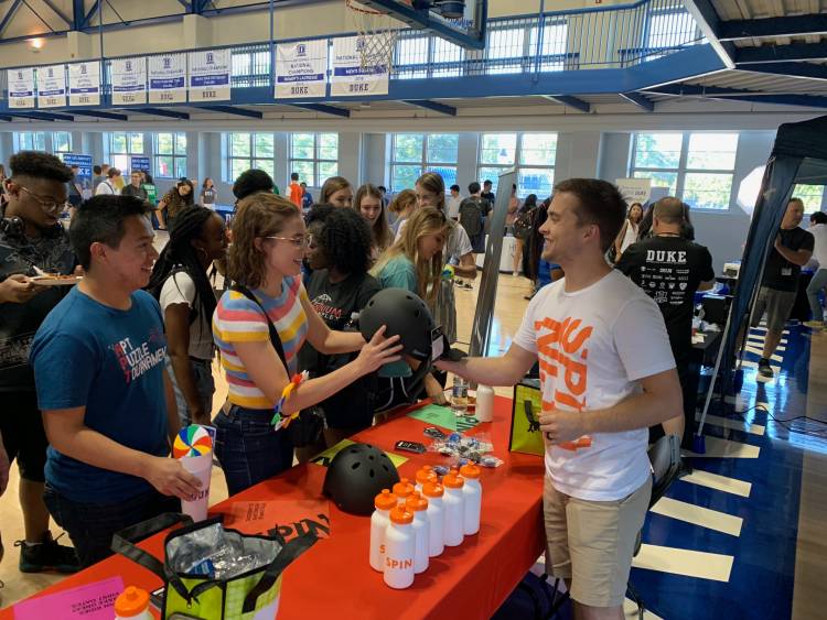 Spin employees hand out helmets to students at RecFest, an annual event that showcases Duke and local organizations. Photo courtesy of Duke Parking & Transportation Services.
