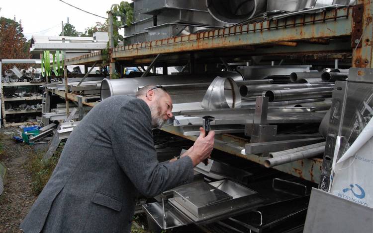 Chip Bobbert measures plates of steel at J & D Recycling. Photo by Stephen Schramm.