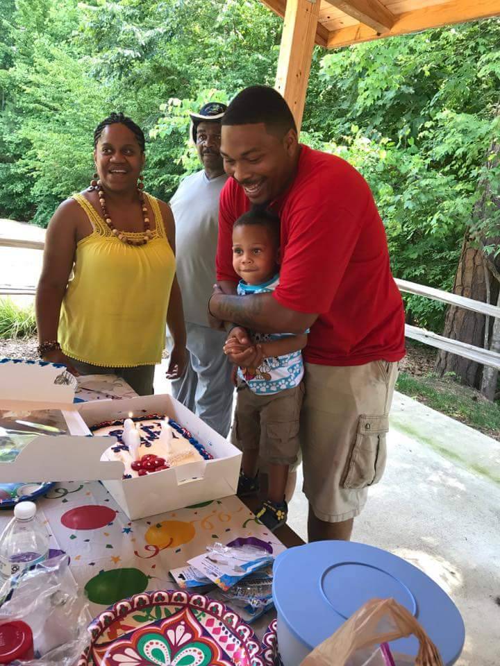 Le'Teya Robinson watches her husband and son blow out the candles on their birthday cake.