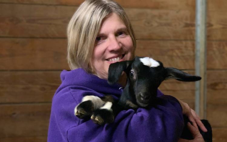 Lori Kiser hugs a baby goat, called a kit, on her farm. Photo courtesy of Lori Kiser.