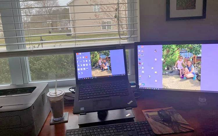 A computer in front of a window.