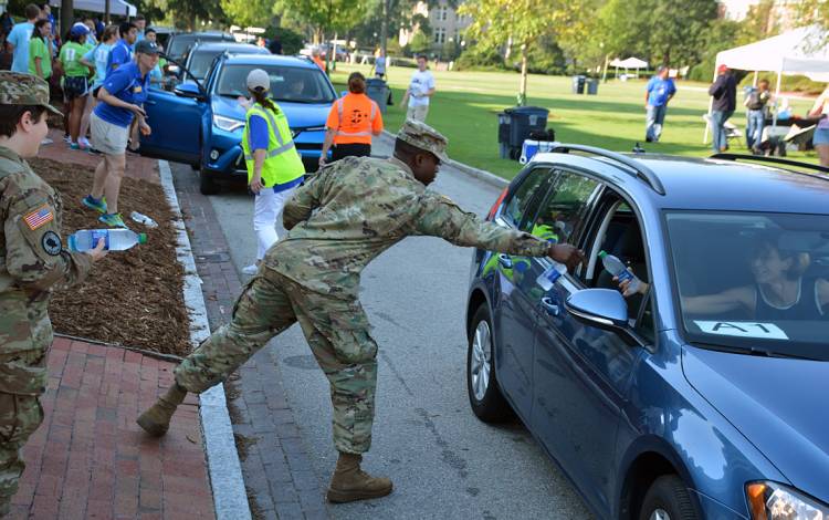 Duke Army ROTC members Amy Kramer and Raheem Adams hand out water to families as they wrap up packing Tuesday morning.