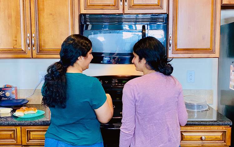 Rupal Vora, left, and her sister cook together at Vora's home. Photo courtesy of Rupal Vora.