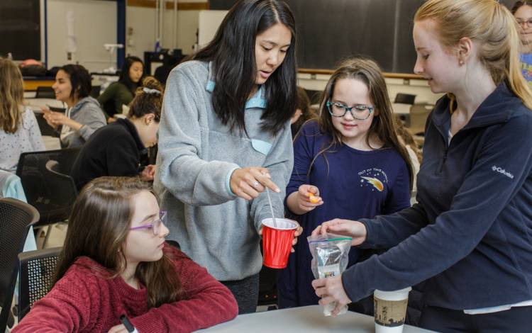 Duke students from FEMMES (Females Excelling More in Math, Engineering and Science) help middle school students with science experiments. Photo by Justin Cook.