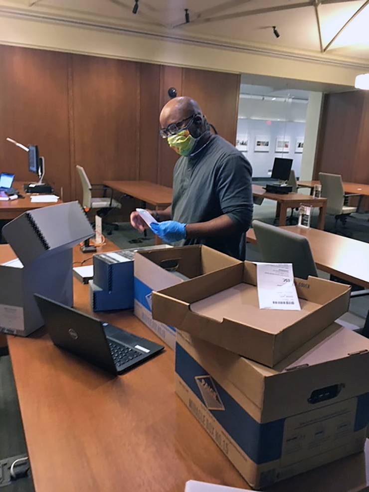John Gartrell, director of the John Hope Franklin Research Center for African and African American History & Culture, helps scan documents for library users. Photo by Janelle Hutchinson.