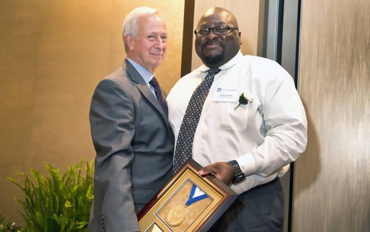 Shelton Perry, right, receives the Presidential Award from former President Richard H. Brodhead.