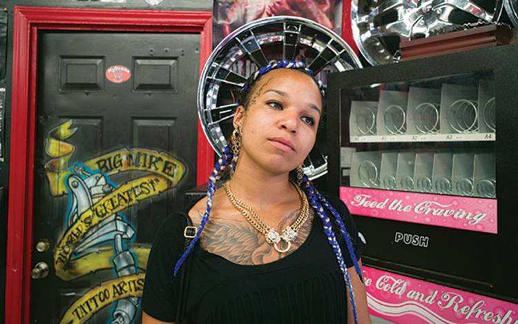 A lady in a tattoo parlor.