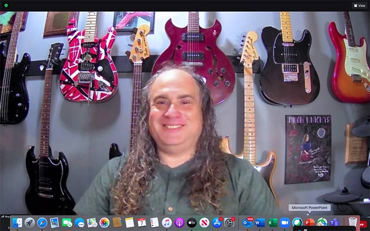 Steve Toback in front of guitars.