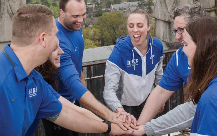 Duke Recreation & Physical Education staff members cheer after climbing 239 steps to the top of Duke University Chapel.