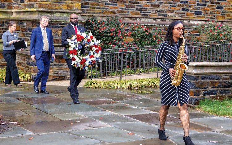 Duke Interim Vice President of Human Resources Antwan Lofton carries a wreath to the Duke Memorial Quadrangle following Friday's Veterans Day ceremony. Photo by Bill Snead.