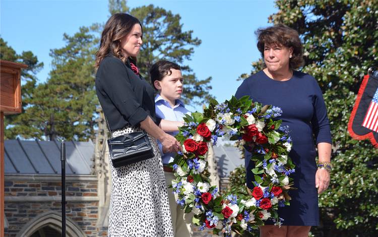 Maj. Agustin Gonzalez's widow Melissa, left, and son, Nick, center, receive a wreath from Duke Associate Vice President for Alumni Affairs Sterly Wilder. Photo by Stephen Schramm.