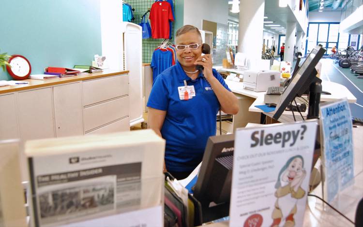 Wanda Parker, shown here prior to the COVID-19 pandemic, enjoys greeting members as they enter the Duke Health and Fitness Center. File photo.