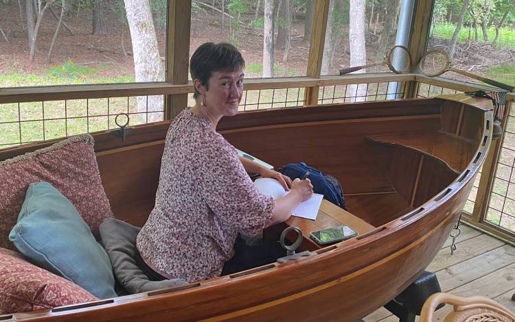 Nicole Barnes, assistant professor of History, writes during the end-of-summer retreat held with 14 women writers. Photo courtesy of Jennifer Ahern-Dodson.