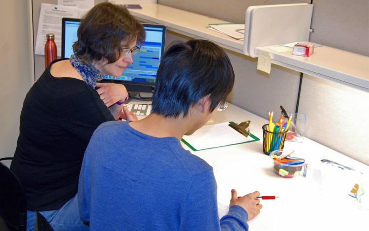 Thompson Writing Program Instructor Margaret Swezey works with graduate student Qiang Miao in the Thompson Writing Studio in Perkins Library. Photo by Stephen Schramm.