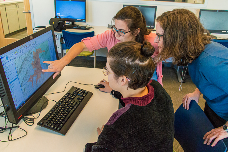 Co-principal investigator Megan Mullin (right) reviews the mapping project with Carolyn Rossman (foreground) and Jannette Morris (top).